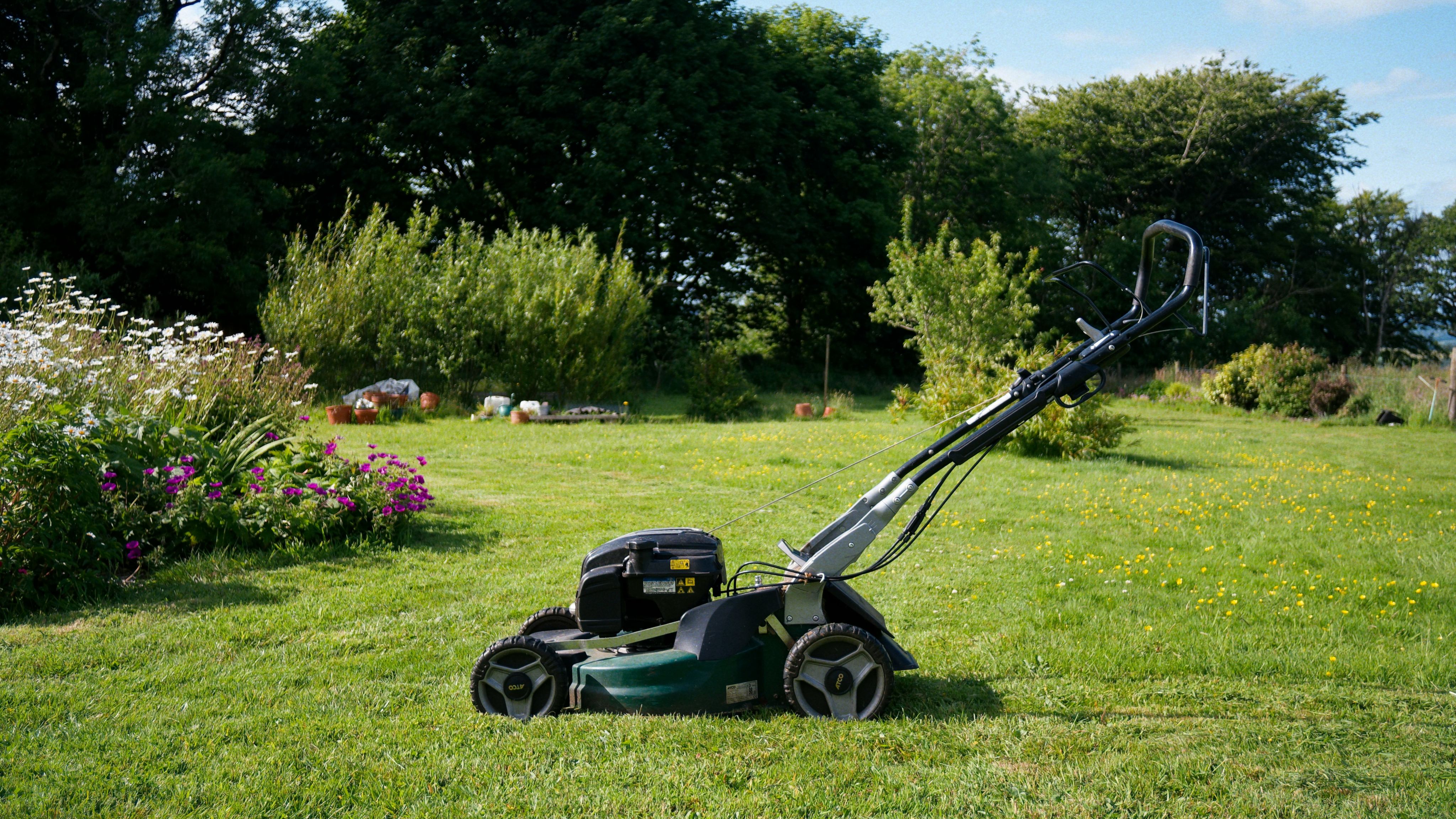A lawnmower sits on a grassy lawn.